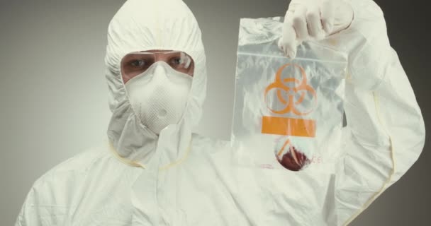 Scienziato laboratorio occhiali di protezione tubo di prova concetto biohazard virus sangue sfondo grigio mostrando — Video Stock