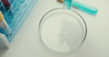 Yakın plan laboratuvar deney tüpü deney tüpü reaksiyonu eldiven eldivenli, mavi aşılı arka plan