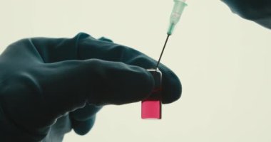 Yakın plan laboratuvar deney tüpü deney tüpü reaksiyonu şırınga eldivenli eller pipet iğnesi beyaz arka plan