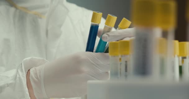 Close-up laboratorio científico asistente guantes tubos de ensayo virus reactivos investigación vacuna coronavirus foco tire — Vídeo de stock
