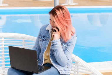 Yüzme havuzuna karşı kot ceketli güzel kız bizi izliyor. Şık kızıl saçlı kadın. Deniz kıyısında serbest çalışan. Öğrenci. İş kadını