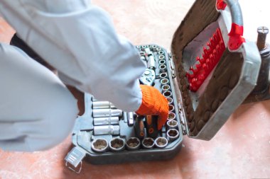 Eldivenli tamirci alet alıyor. onarım için anahtarlar ve araçlar