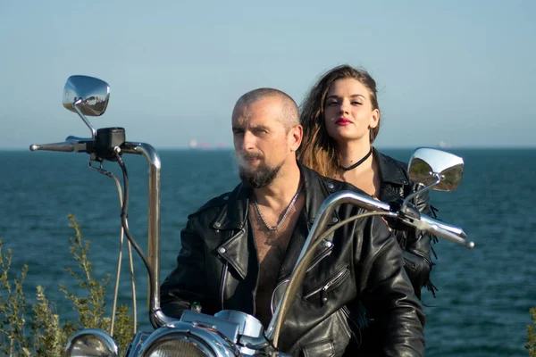 funny and hot bikers with expensive motorcycle. Hot woman and handsome guy. Beautiful couple have fun together