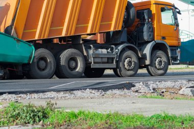Yol silindirleri yeni asfalt yolu inşa ediyor. Vagon, kamyon, yürüyüş makinesi.