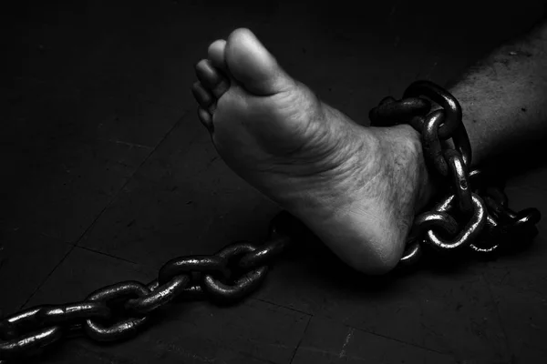 Oběť, otrok, zajatec mužské foor svázána velký kovový řetízek. — Stock fotografie