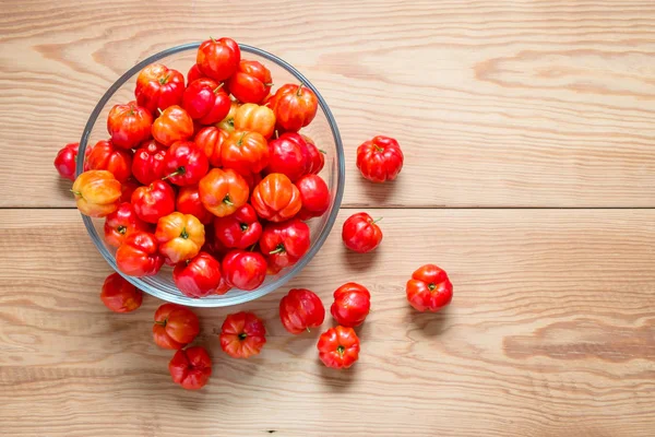 ahşap masa üzerinde bir cam kapta taze kiraz