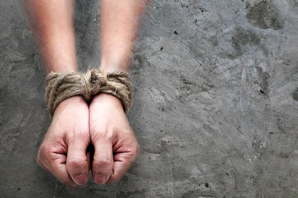 Vítima, escravo, prosoner mãos masculinas amarrado por grande corda no concr — Fotografia de Stock