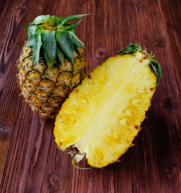 Ananas ile bir buçuk bir dilim üzerinde ahşap masa.