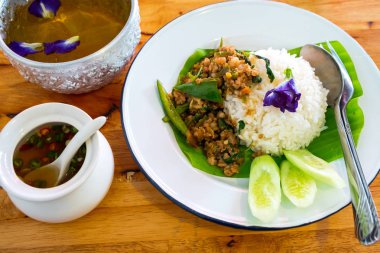 Tavada kızartılmış domuz eti ve fesleğen ahşap tablo ile tepesinde pirinç