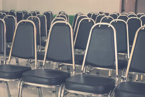 Rows of Empty Black Leather Chairs in a Meeting Room.