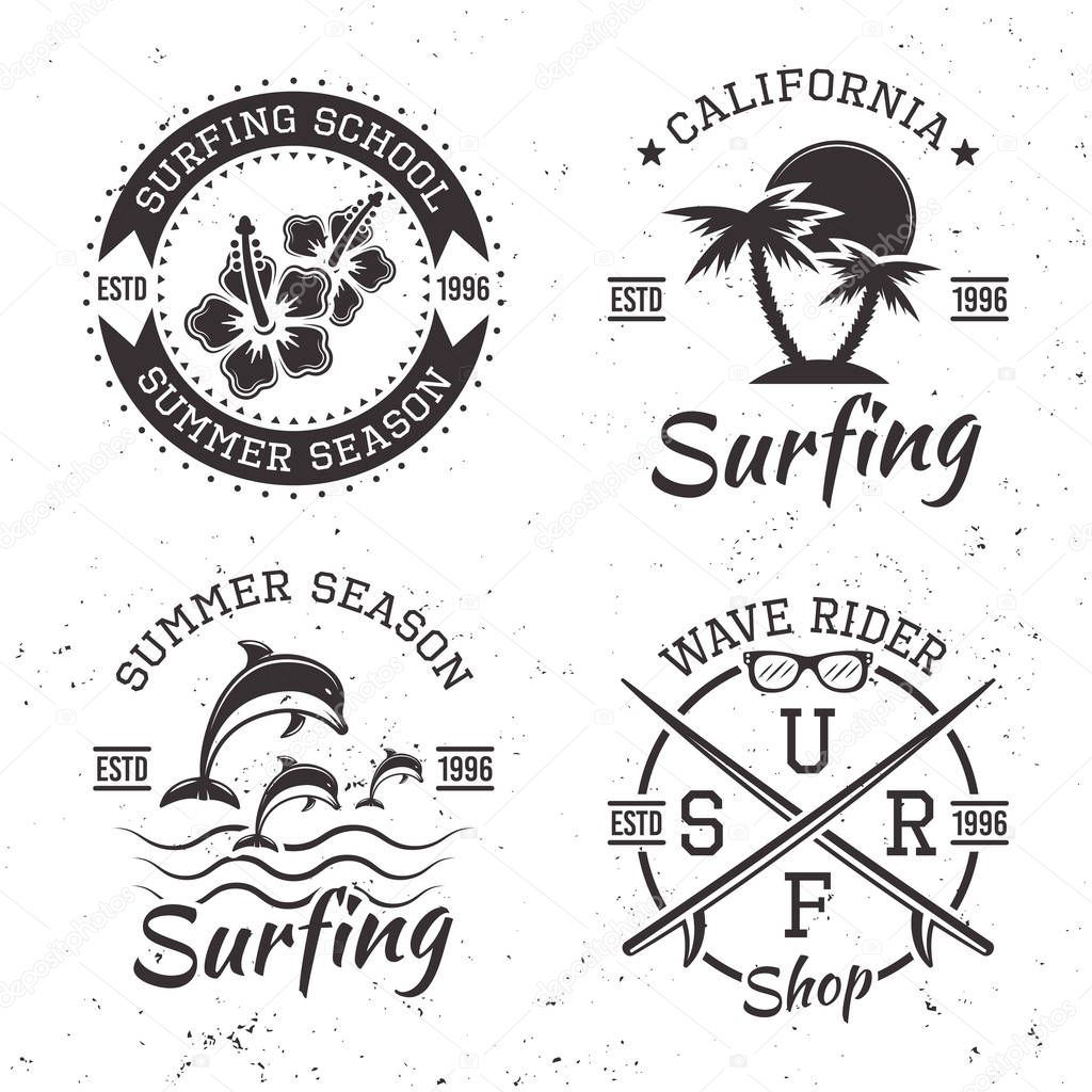 Surfing set of four black vector emblems, badges, labels and logos in vintage style isolated on white background with grunge texture