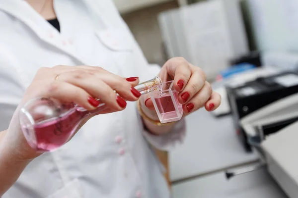 Scientist working with chemical reaction in chemistry lab. Chemical reaction in glass flask. Lab worker doing chemical experiment in laboratory