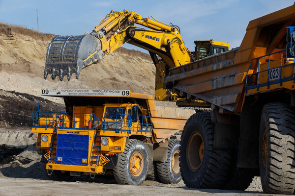 Coal section, Primorsky Krai, Russia - March 2017: chalk pit. Excavator pours soil into the truck