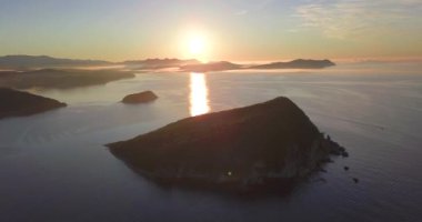 Yukarıdan ateş ediyorlar. Şafak vakti Primorsky Bölgesi 'nin Lazovsky Reserve' indeki Petrov adasının üzerinde uçacağız. Güneş ufuktan yükselir denizin ve adanın arka planına karşı.