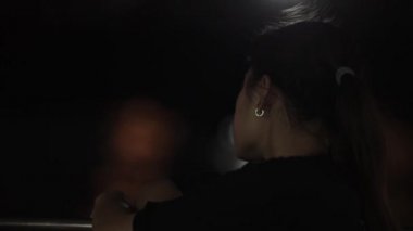 Ağır çekim. Chao Phraya Nehri, Bangkok. Genç bir kız sırtında kamerayla bir yolcu feribotuna biner ve Chao Phraya Nehri 'nin gece manzarasına bakar..