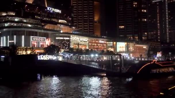 チャオプラヤ川 明るいお店 ショッピングセンター レストランの中で川の夜にボートに乗ってセーリング — ストック動画