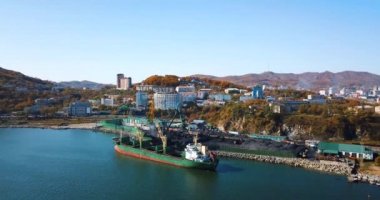 Kömür portu. Nakhodka 'nın küçük bir kasabasındaki bir kömür limanında uçuyor. Kömür, deniz kömür limanındaki bir kargo gemisine yükleniyor..