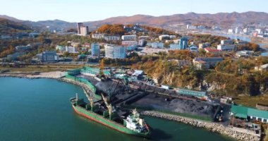 Kömür portu. Nakhodka 'nın küçük bir kasabasındaki bir kömür limanında uçuyor. Kömür, deniz kömür limanındaki bir kargo gemisine yükleniyor..