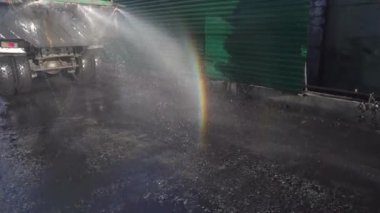 Yakın plan. Araba Nakhodka 'nın kömür ticareti limanındaki kömür tozundan temiz asfalt döküyor. Islak temizlik..