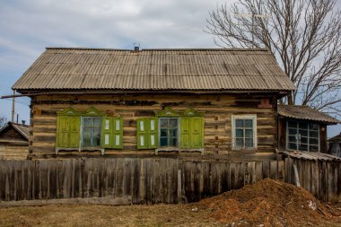 Rus köyü. Tahta çitlerin arkasındaki ahşap çiftlik evi. Rus köyünde bir kulübe..