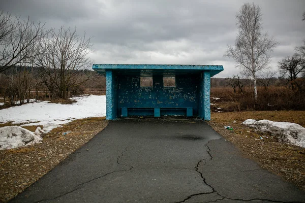 Russian village. Concrete public transport stop without people in the middle of a road in a Russian village