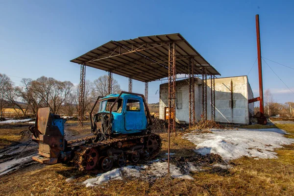 ロシアの村古い壊れたトラクターはロシアの村のレンガボイラー室に対して立っています — ストック写真
