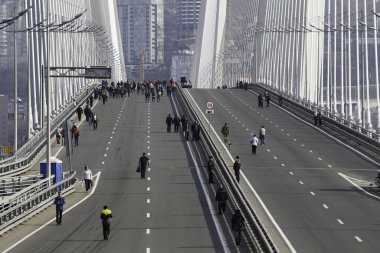 Mayıs 2015 - Vladivostok, Rusya - Vladivostok 'un merkez caddesi üst üste biniyor. Neşeli bir kalabalık, Mayıs Bayramı kutlamalarında bayraklar ve balolarla Altın Köprü boyunca yürür..
