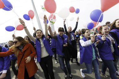 Mayıs 2015 - Vladivostok, Rusya - Vladivostok 'un merkez caddesi üst üste biniyor. Neşeli bir kalabalık, Mayıs Bayramı kutlamalarında bayraklar ve balolarla Altın Köprü boyunca yürür..