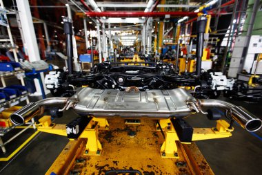 Araba fabrikası. Parçalanmış arabanın metal ünitesi bir taşıyıcı bandın üzerinde duruyor..