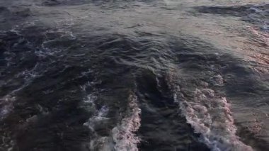 Ağır çekimde çekim. Chao Phrai Nehri, Bangkok 'ta. Yakın plan. Tekne nehrin suyunu keser. Motor işleminden gelen dalgalar.