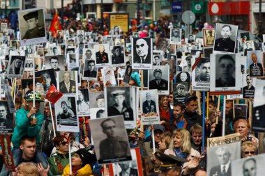 Mayıs 2015 - Vladivostok, Rusya - Vladivostok 'ta Zafer Günü. Harekat Ölümsüz Alayı. İnsanlar, Zafer Günü geçit töreninde Vatanseverlik Savaşı 'nda savaşmış atalarının binlerce fotoğrafını taşıyor..
