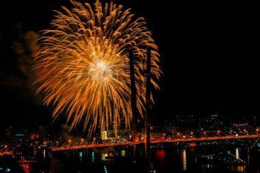 Vladivostok 'ta havai fişekler. Vladivostok 'taki Zafer Günü' nün anısına, Altın Köprü 'nün ve şehrin merkezi kesiminin arkaplanına selam verin..