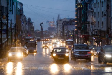 2015 yazında - Vladivostok, Rusya - Vladivostok sokakları yağmurdan ıslandı. Yağmur sırasında, su birikintileri arasında arabalar şehrin merkezinden geçer..