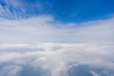 Bir uçağın lombozundan görüntü. 10.000 metre yükseklikten güzel bir beyaz bulut manzarası..