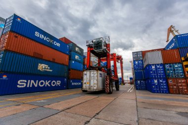 2015 Yazı - Vladivostok, Rusya - Vladivostok Deniz Konteyner Terminali. Bir konteynır yüklü bir yükleyici konteynırların arka planına karşı bir ticaret portu bölgesi boyunca hareket eder