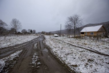 Primorsky Bölgesi 'nde Rusya' ya dönen Latin Amerikalı eski inananların köyü. Eski inananların ahşap evleri güzel tarlalar ve dağların arka planında kar yağışı sırasında.