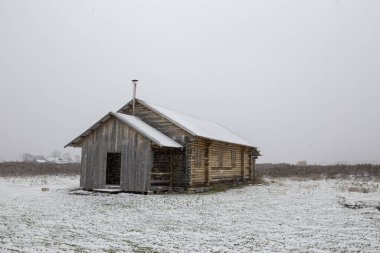 Primorsky Bölgesi 'nde Rusya' ya dönen Latin Amerikalı eski inananların köyü. Eski inananların ahşap evleri güzel tarlalar ve dağların arka planında kar yağışı sırasında.