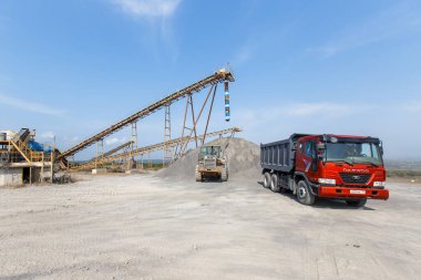 2015 sonbaharında - Primorsky bölgesi, Rusya - Sanayi fotoğrafçılığı. Sarı kazıcı bir kum ocağında çalışıyor. Ağır bir kazıcı büyük bir kazıda bir tseben tırmıklıyor.