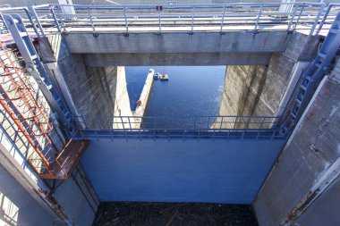 Sanayi fotoğrafçılığı. Sakin mavi suyun arka planına karşı Zeya hidroelektrik santralinin kapalı kilitleri.