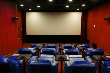 Sinemada boş VIP odası. Beyaz bir sinema perdesinin arka planında sinemada boş mavi koltuklar.