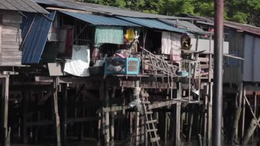 2019 baharında Bangkok, Tayland 'da Chao Phraya Nehri' nde tekne gezisi. Ağır çekim. Bangkok 'un yoksul bir bölgesinde bir turist teknesi gecekondu mahallelerinden geçiyor