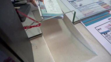 2019 baharında, Bangkok, Tayland 'da Yavaş Hareket. Yakın plan. Denetleyici, zevk teknesi için biletleri gişenin penceresinden geçirir..