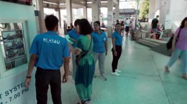 2019 baharında, Bangkok, Tayland 'da Yavaş Hareket. Bir kadın bilet gişesinden turist feribotu bileti alır ve Bangkok River İstasyonu 'ndaki yolcu platformuna gider.