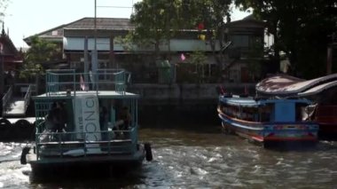 2019 baharında, Bangkok, Tayland 'da Yavaş Hareket. Bangkok 'taki Chao Phraya Nehri' nde demirli bir turist eğlence teknesinin yanından geçiyor. Bangkok 'un ana nehrindeki nehir rıhtımı.