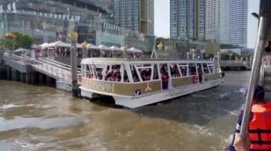 2019 baharında, Bangkok, Tayland 'da Yavaş Hareket. Chhao Praia Nehri 'ndeki nehir rıhtımında bir turist teknesi duruyor. Turistler bir zevk gemisine biner.