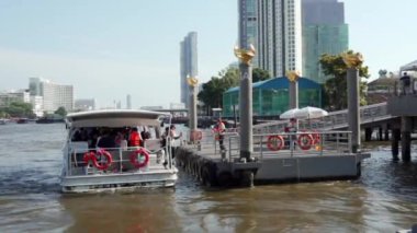 2019 baharında, Bangkok, Tayland 'da Yavaş Hareket. Chhao Praia Nehri 'ndeki nehir rıhtımında bir turist teknesi duruyor. Turistler bir zevk gemisine biner.