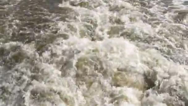 Gros plan. Au ralenti. Un coup d'eau de rivière brune bouillonnante provenant d'un moteur en marche. Piste du travail d'un moteur à eau .