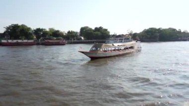 2019 yazında, Bangkok, Tayland 'da Chao Phraya Nehri boyunca tekne turu. Bangkok 'un ana nehrinde bir turist teknesi yüzüyor. Yavaş Hareket.