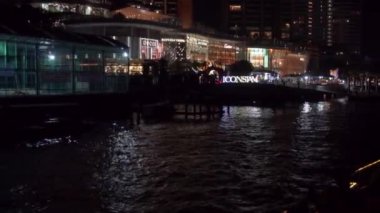 2019 yazında Bangkok, Tayland 'da Bangkok' un ana nehri Chhao Praia boyunca bir turist teknesinde gece yürüyüşü. Turistlerle dolu bir tekne yüksek binaların ve parlak alışveriş merkezlerinin önünden yüzüyor..