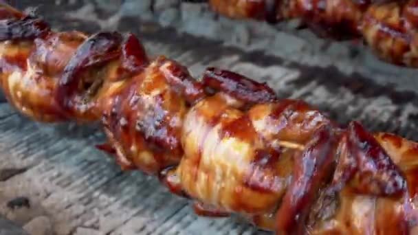 Gros plan. Un délicieux kebab appétissant de carcasse de poulet tourne sur des charbons sur une broche. Griller des brochettes de poulet entières .